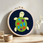 Colorful little turtle punch needle artwork displayed on a table