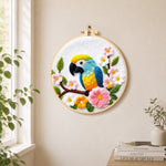 Colorful macaw parrot with flowers needle felt wall art displayed in a bright home interior