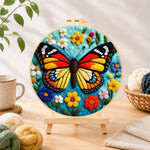 Finished colorful monarch butterfly and wildflowers needle felting displayed on a wooden easel