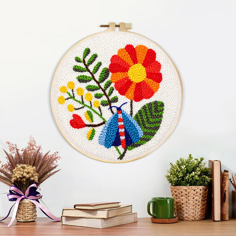 Finished colorful moth and large flower artwork displayed on a wall
