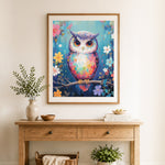Finished colorful owl among wildflowers cross stitch artwork displayed as home decor