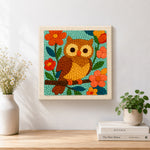 Finished colorful owl on flowering branch artwork displayed on a wall