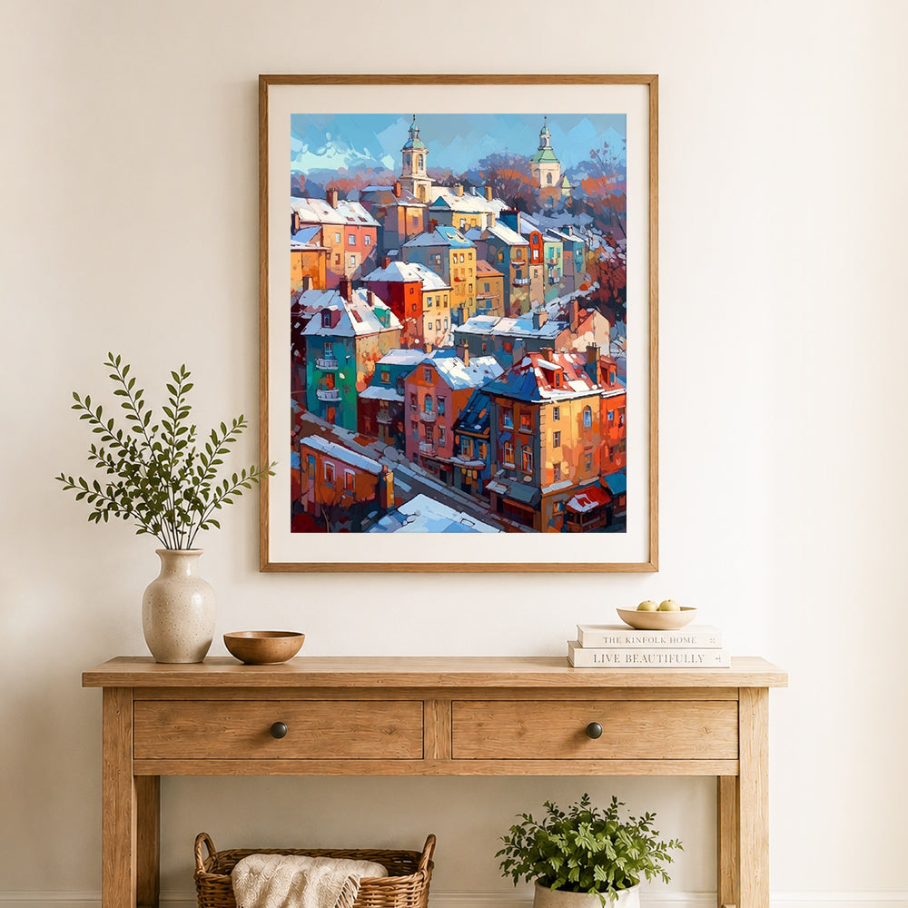 Finished colorful snowy european town cross stitch artwork displayed as home decor