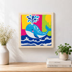 Finished colorful spouting whale artwork displayed on a wall