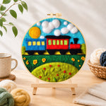 Finished colorful train on grass needle felting displayed on a wooden easel
