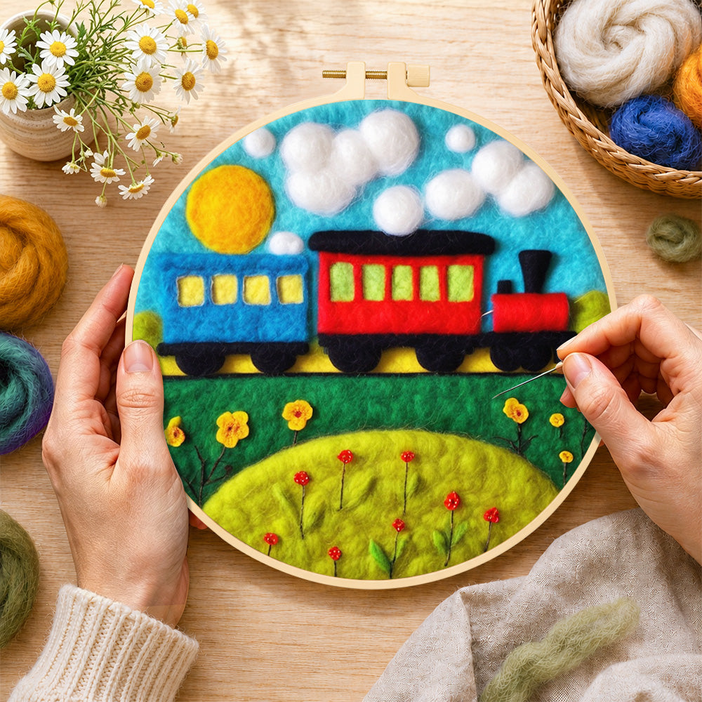 Creating the colorful train on grass wool painting by hand with a felting needle