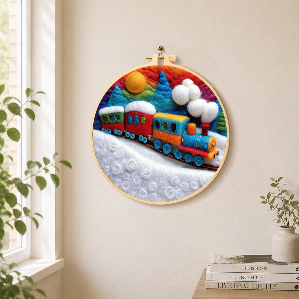 Colorful train on snowy hills needle felt wall art displayed in a bright home interior