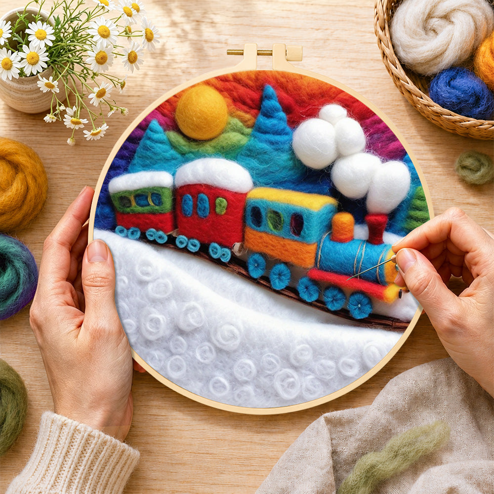 Creating the Colorful train on snowy hills wool painting by hand with a felting needle