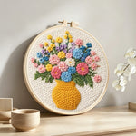 Colorful wildflowers in yellow vase punch needle artwork displayed on a table