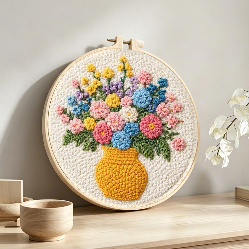 Colorful wildflowers in yellow vase punch needle artwork displayed on a table