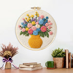 Finished colorful wildflowers in yellow vase artwork displayed on a wall
