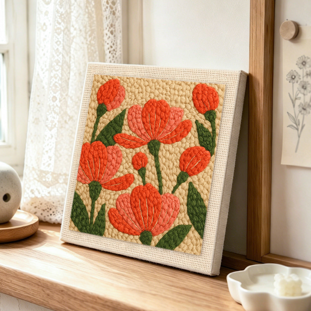 Coral pink flowers punch needle artwork displayed on a table