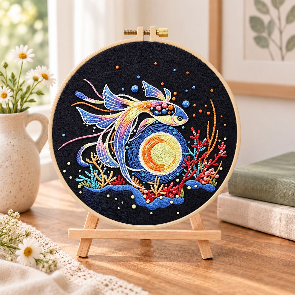 Cosmic betta fish embroidery kit finished hoop displayed on a wooden stand as cozy tabletop decor