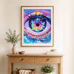 Finished cosmic neon eye cross stitch artwork displayed as home decor