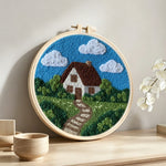 Countryside cottage with pathway punch needle artwork displayed on a table