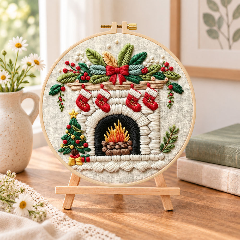Cozy christmas fireplace embroidery kit finished hoop displayed on a wooden stand as cozy tabletop decor