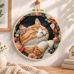 Cozy napping orange cat embroidery hoop wall art displayed as warm and cozy handmade home decor