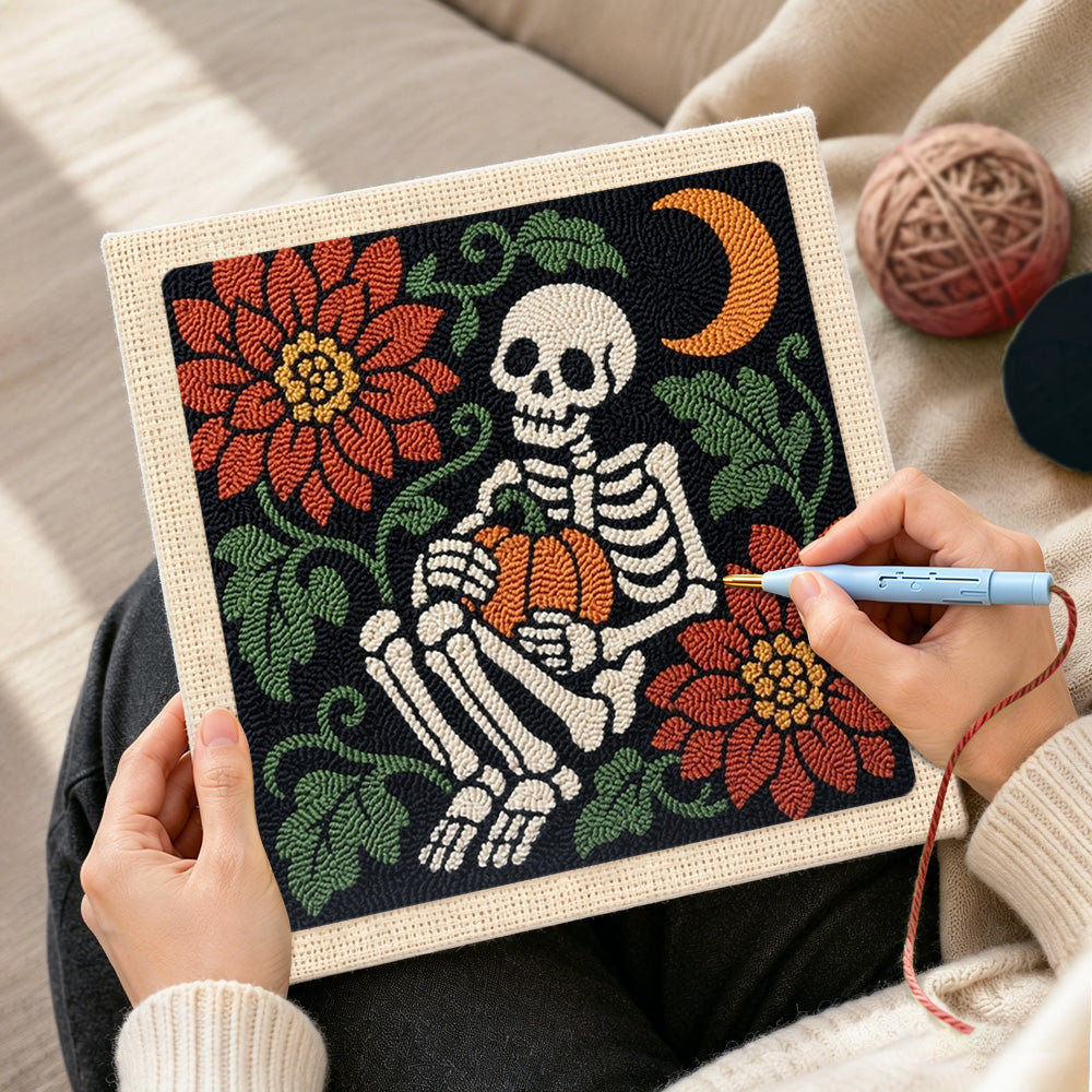 Creating handmade cozy skeleton holding pumpkin punch needle artwork