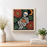 Finished cozy skeleton holding pumpkin artwork displayed on a wall