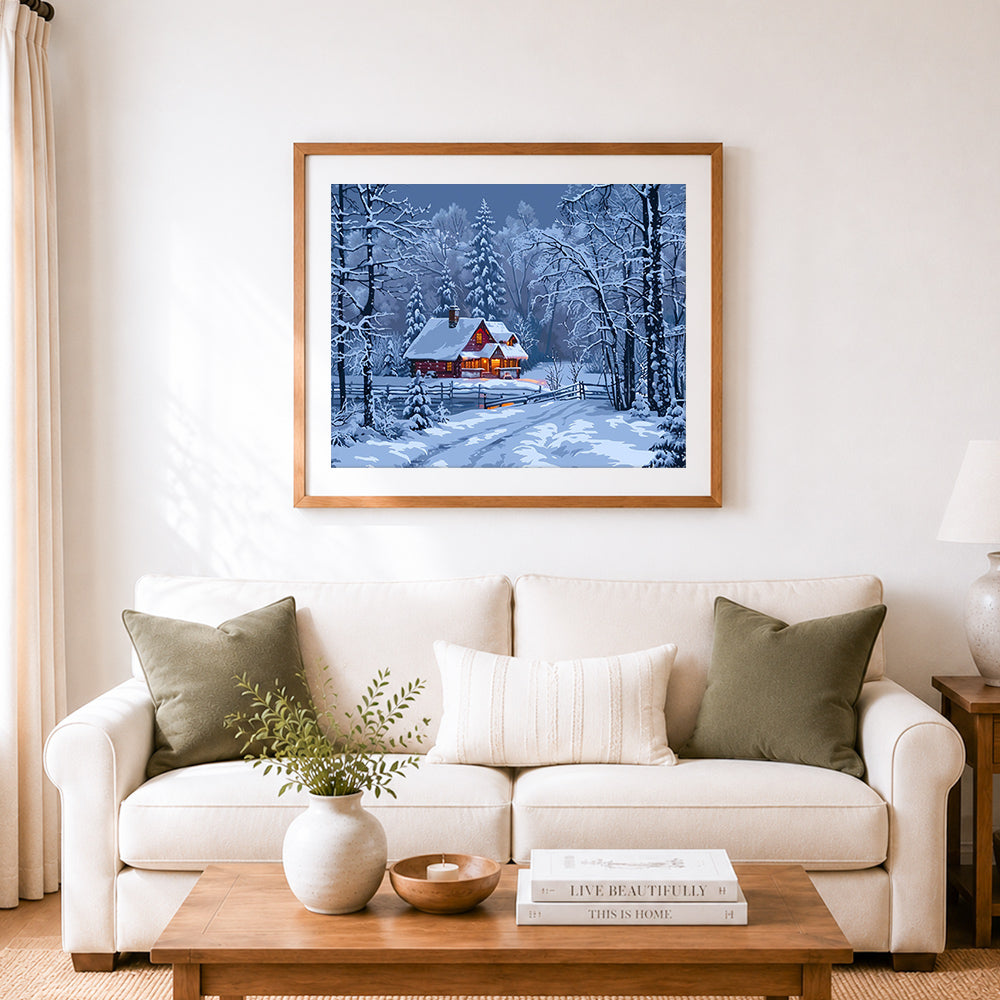 Finished cozy snow cabin in winter woods cross stitch artwork displayed as home decor