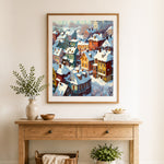 Finished cozy snow‑covered colorful town cross stitch artwork displayed as home decor
