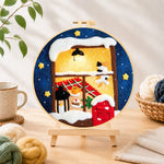 Finished cozy winter window needle felting displayed on a wooden easel