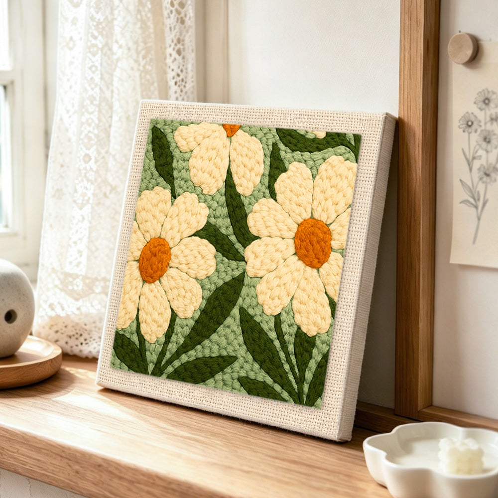Creamy white daisy flowers punch needle artwork displayed on a table