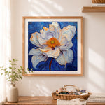 Finished creamy white flower on deep blue cross stitch artwork displayed as home decor