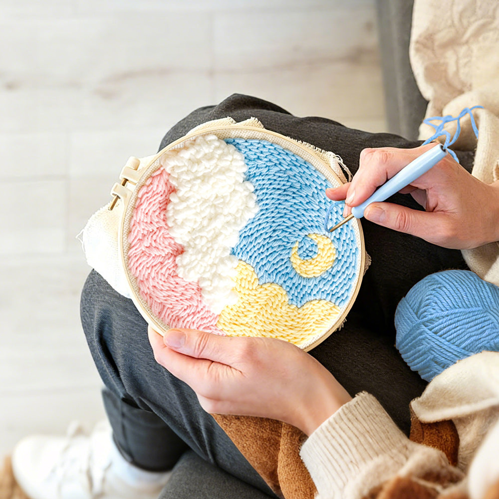 Creating handmade crescent moon over colorful clouds punch needle artwork