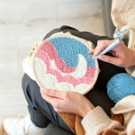 Creating handmade crescent moon over pink and white clouds punch needle artwork