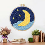 Finished crescent moon over starry night sky artwork displayed on a wall