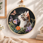 Curious cat and pink butterfly embroidery hoop wall art displayed as warm and cozy handmade home decor