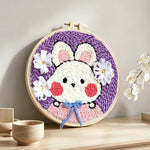 Cute bunny with blue bow punch needle artwork displayed on a table