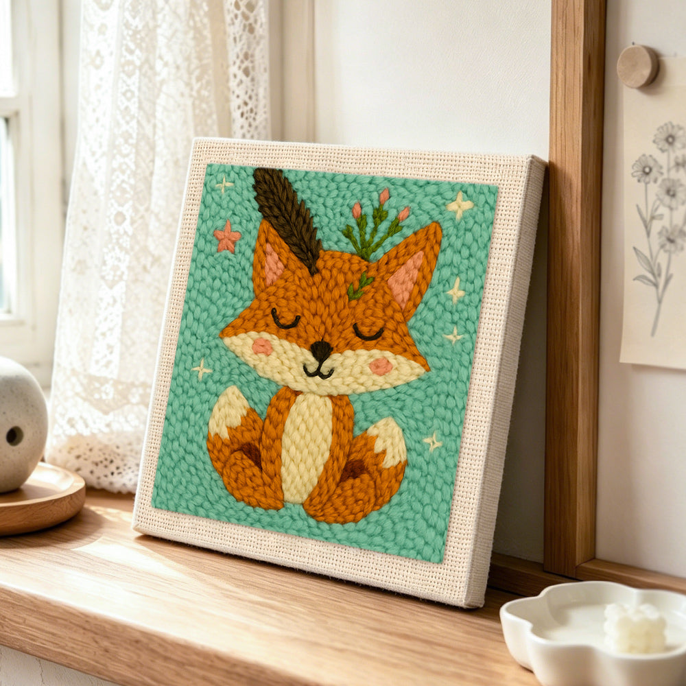 Cute fox with feathers and sprigs punch needle artwork displayed on a table