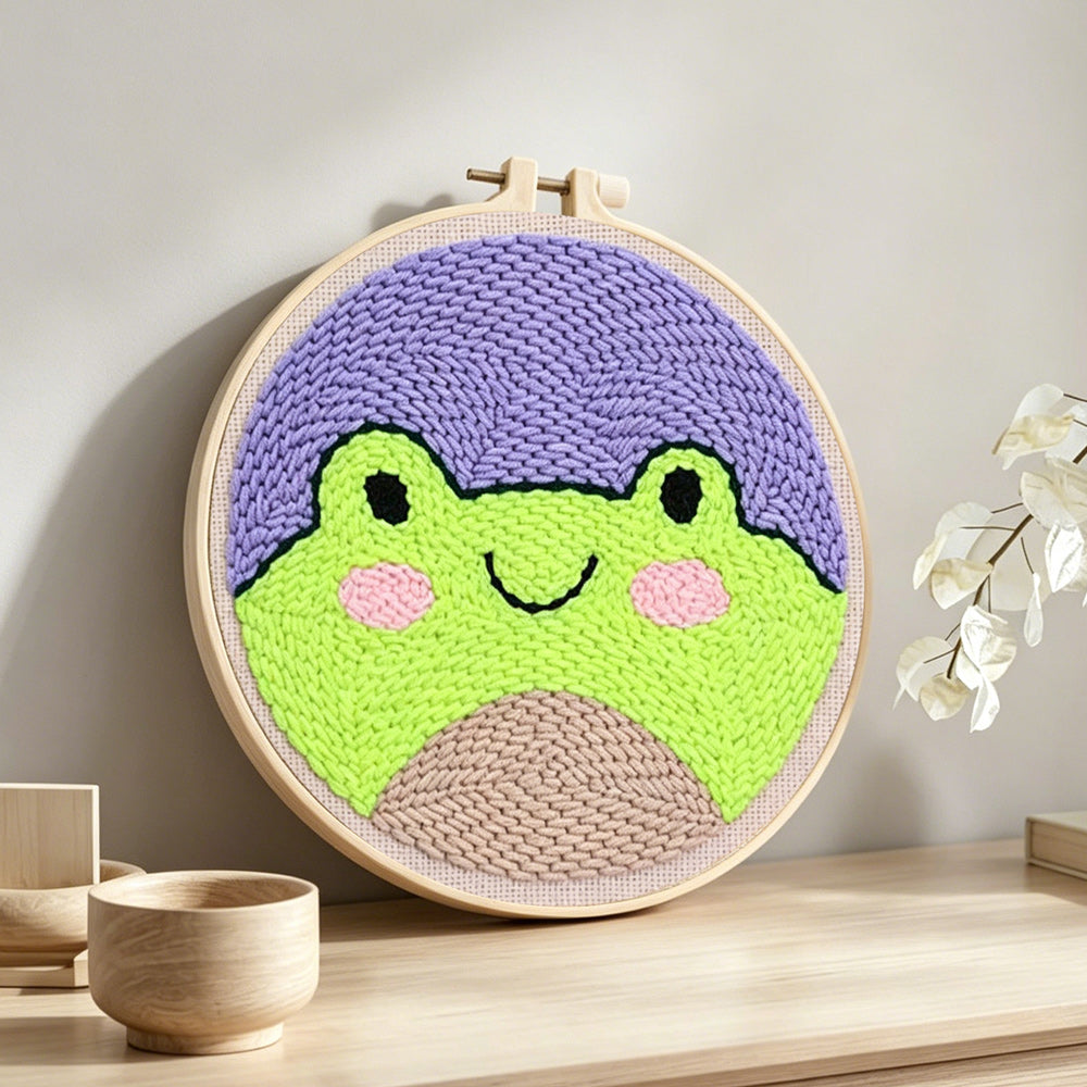 Cute frog face punch needle artwork displayed on a table