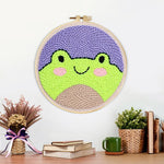Finished cute frog face artwork displayed on a wall