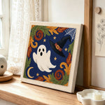Cute ghost and witch hat design punch needle artwork displayed on a table