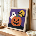 Cute ghost with jack‑o‑lantern punch needle artwork displayed on a table
