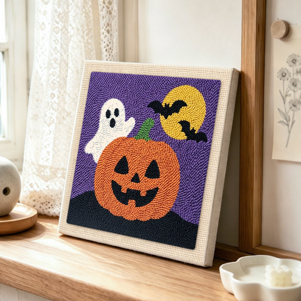 Cute ghost with jack‑o‑lantern punch needle artwork displayed on a table