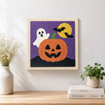 Finished cute ghost with jack‑o‑lantern artwork displayed on a wall