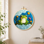 Cute green frog under the cloud needle felt wall art displayed in a bright home interior