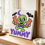 Cute green skeleton with candy punch needle artwork displayed on a table