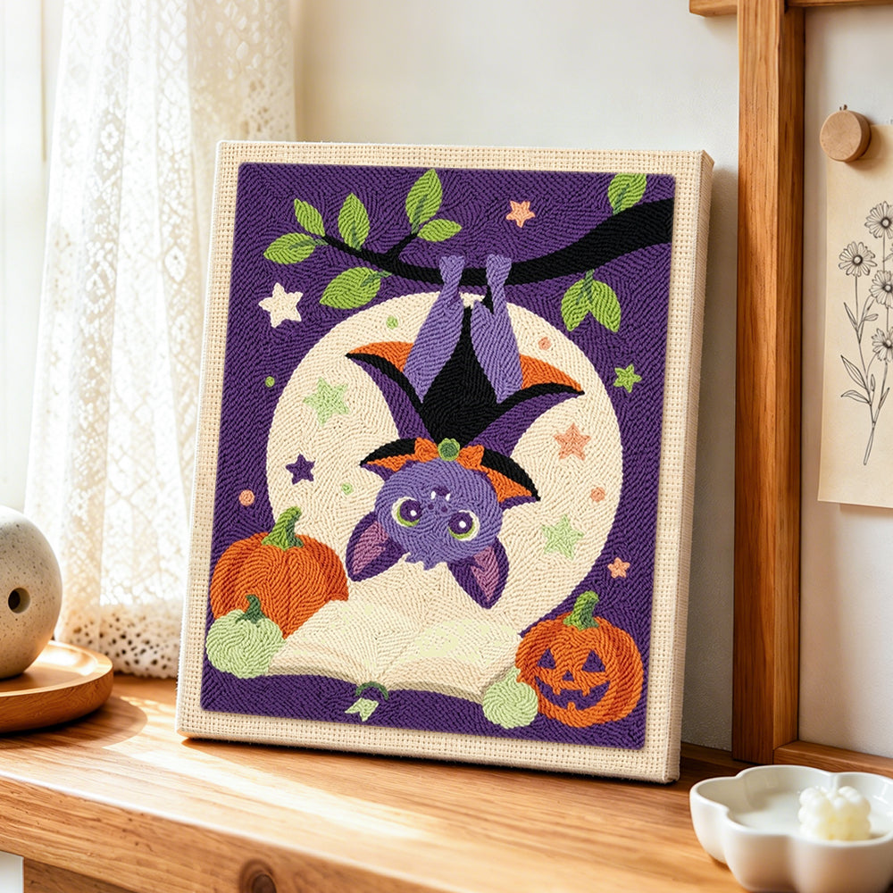 Cute hanging bat with pumpkins punch needle artwork displayed on a table