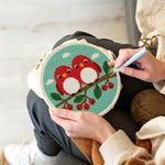 Creating handmade cute red birds on berry branch punch needle artwork