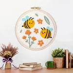Finished cute smiling bumblebees and orange flowers artwork displayed on a wall