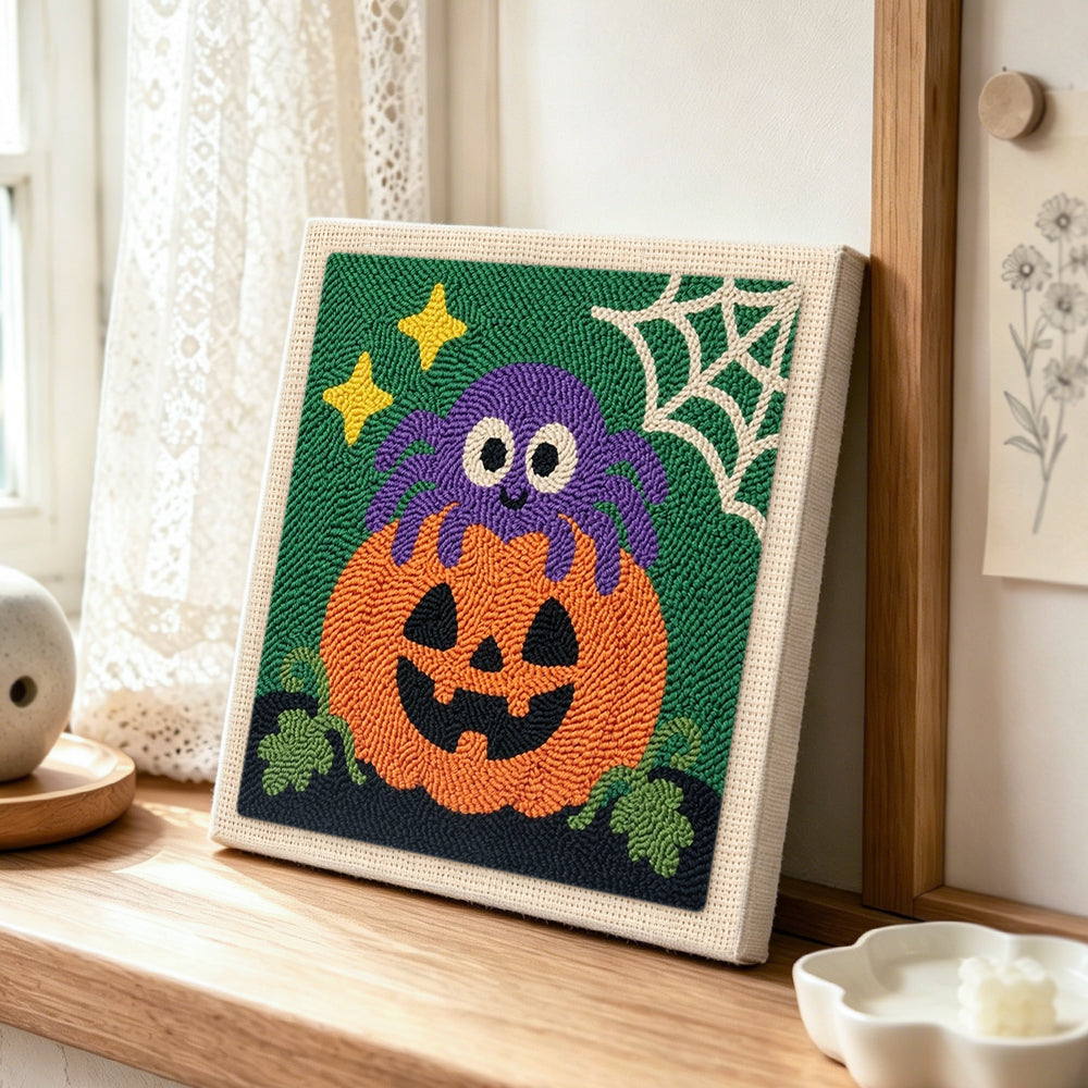 Cute spider pumpkin punch needle artwork displayed on a table