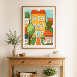Finished cute town cottage cross stitch artwork displayed as home decor