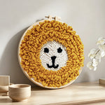 Cute yellow lion face punch needle artwork displayed on a table
