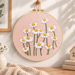 Daisies on dusty pink fabric embroidery hoop wall art displayed as warm and cozy handmade home decor