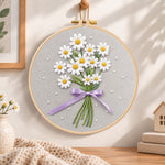 Daisy bouquet with purple ribbon embroidery hoop wall art displayed as warm and cozy handmade home decor
